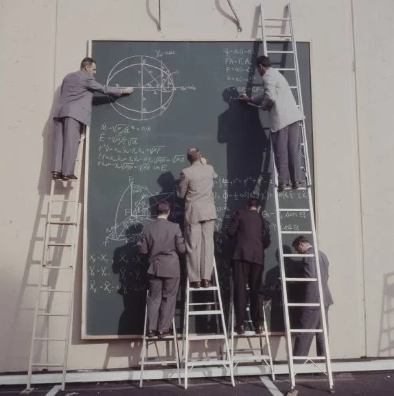 Científicos de la NASA escribiendo ecuaciones en una gran pizarra